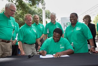 Photo Mayor Brown signing the legislation as Council Members Bill Gulliford, Don Redman, and Denise Lee look on.
