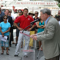 Jake Godbold speaking with fire truck in background